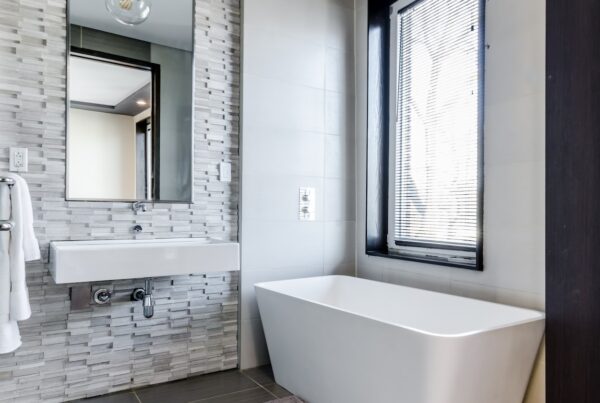 white ceramic bathtub near white framed window